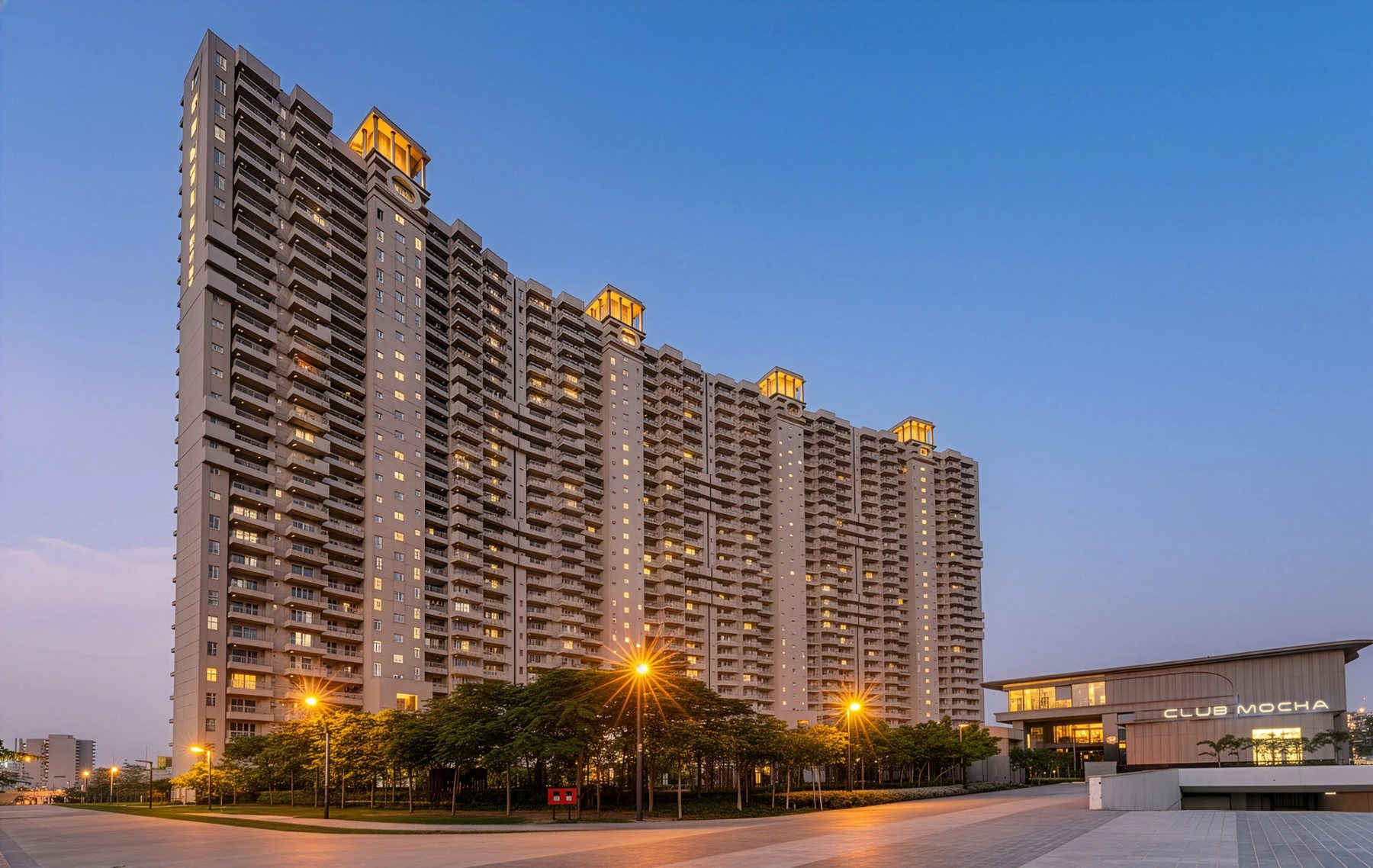The Centre Court, Phase 1 of the colony: four connected residential towers at dusk with the Club Mocha clubhouse on the right.